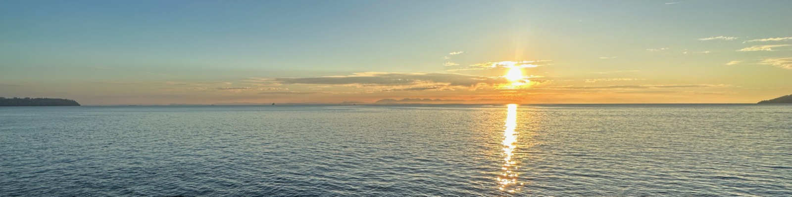 Evening sunlight reflected across calm coastal water
