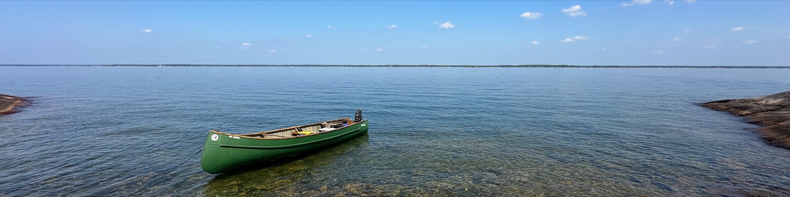A canoe resting in clear water between rocky shores